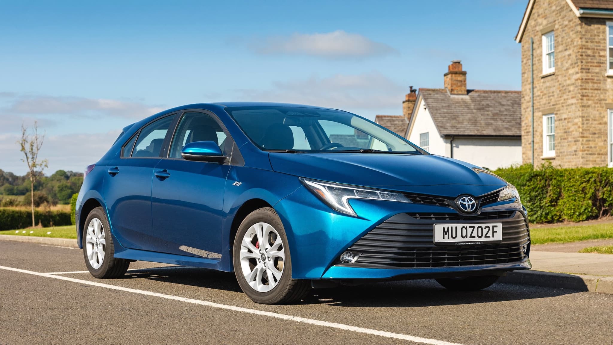 A silver Toyota Auris hybrid on a golden-hour UK city street