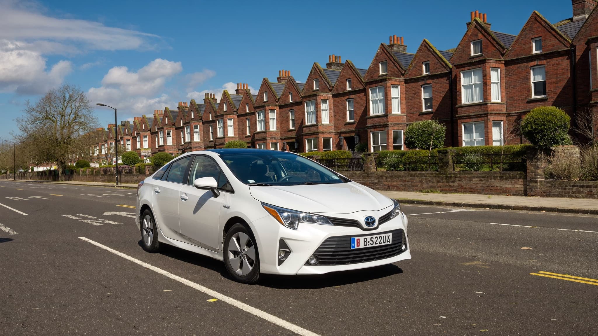 A silver Toyota Prius on a golden-hour UK city street